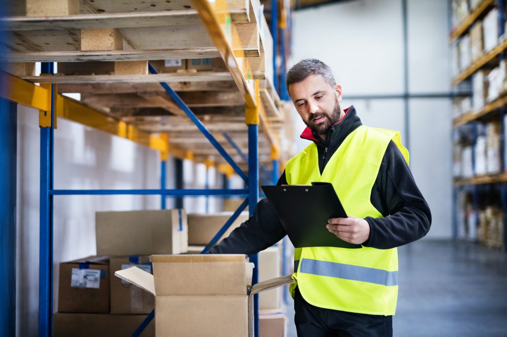 A warehouse employee check inventory boxes and data.